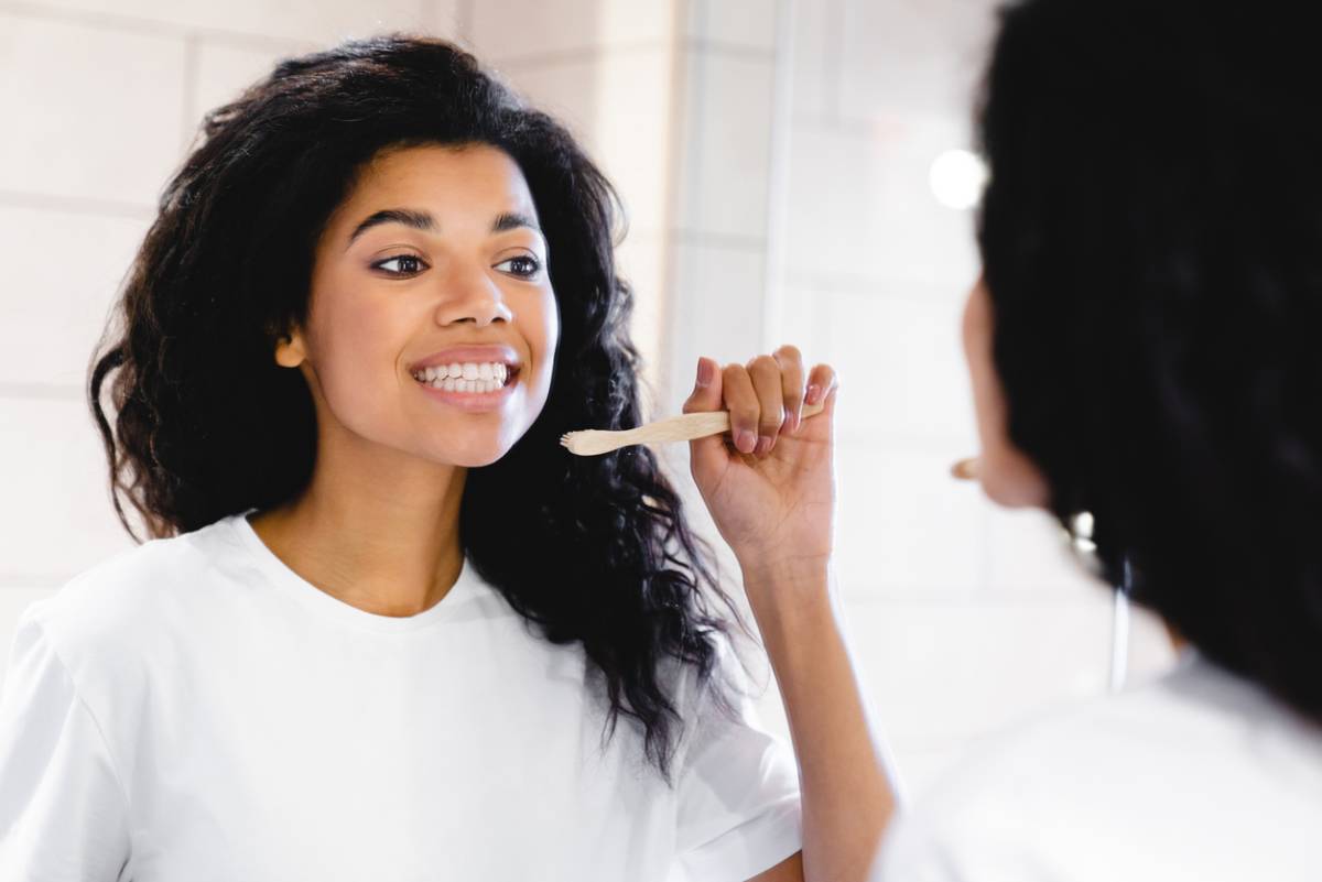 Woman brushing teeth and caring for dental crowns